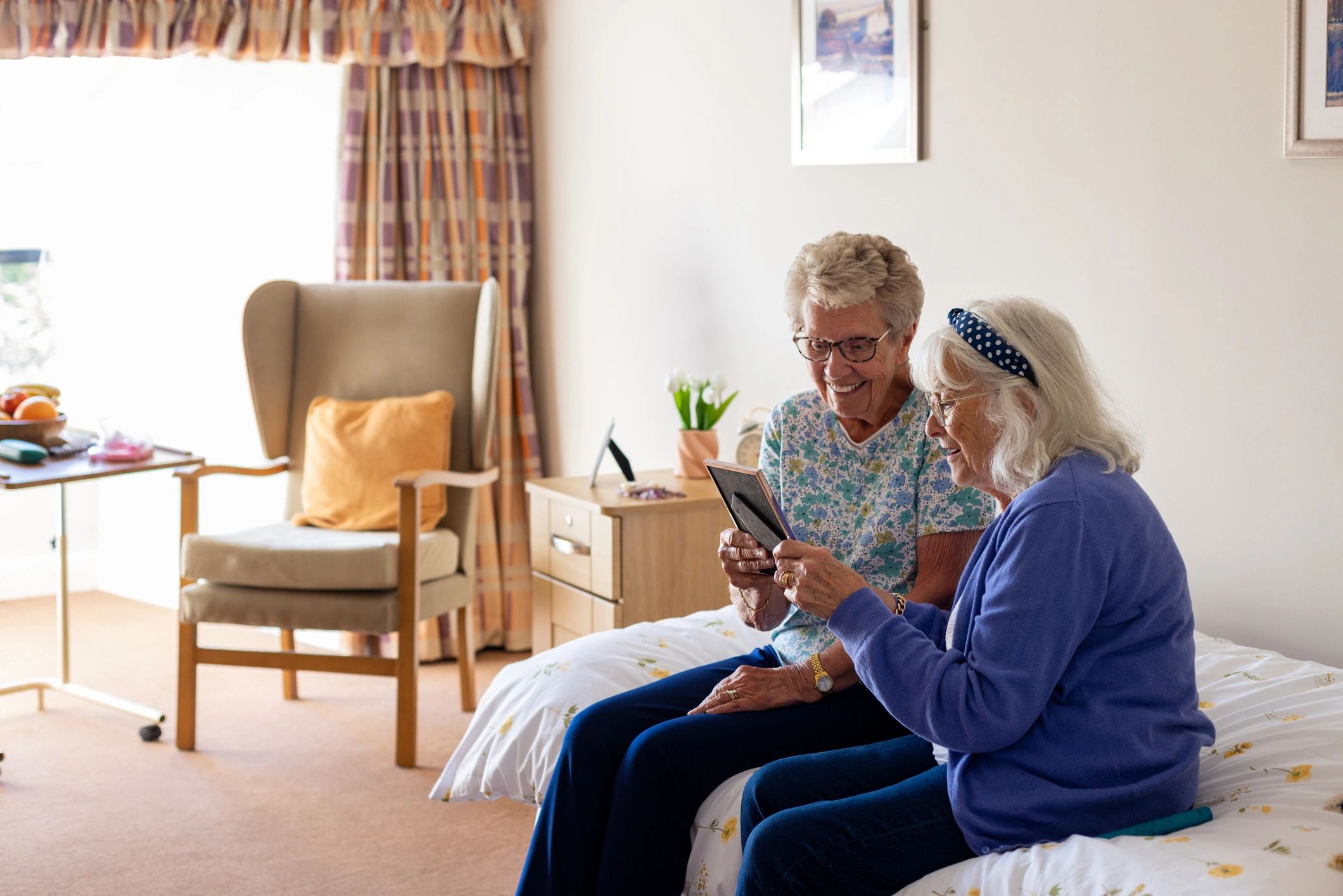 Companion visit with two seniors sharing a warm moment at home