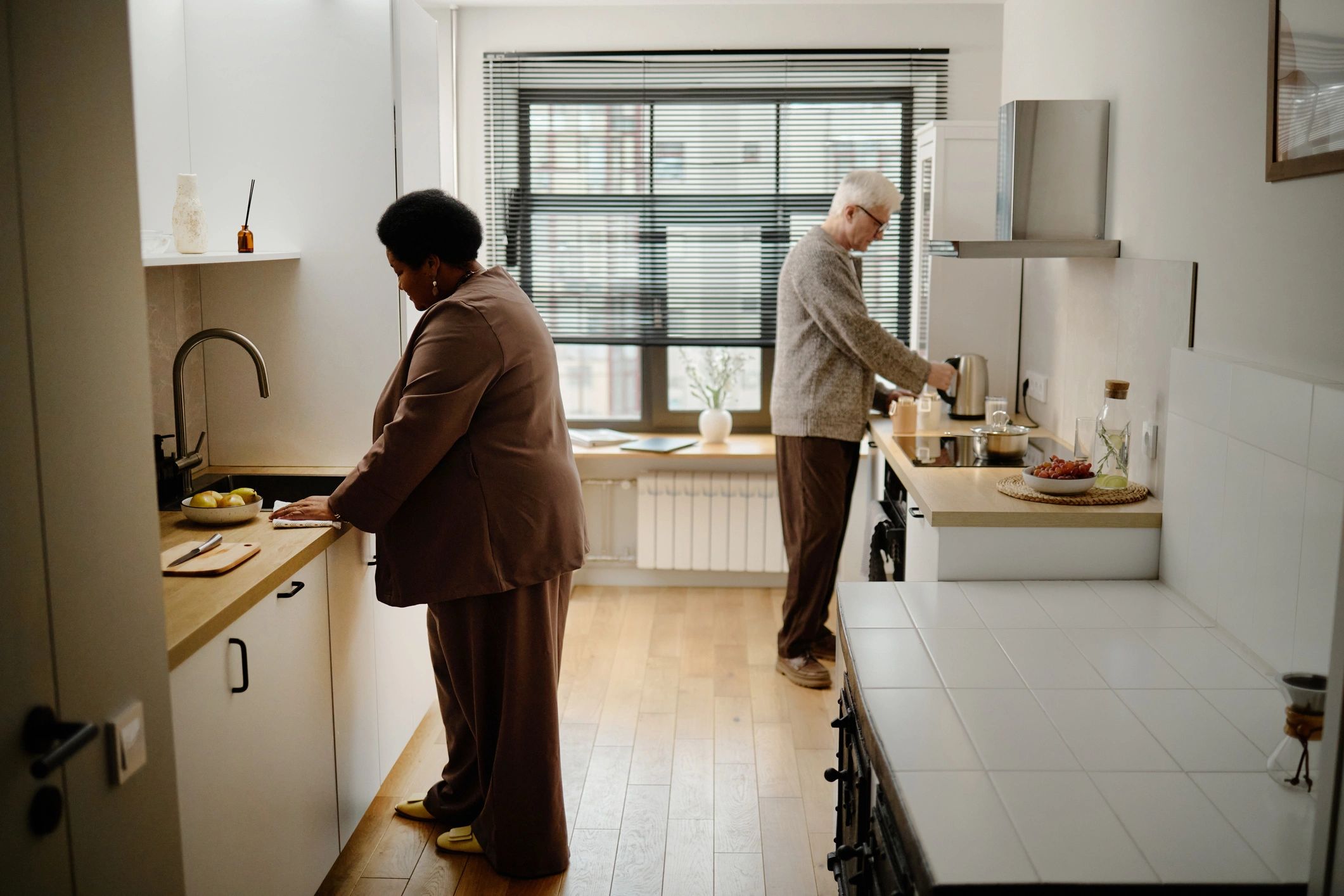 Senior companions preparing food together in a modern kitchen